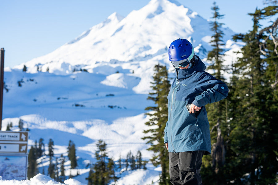 Snowboarder in front of Mt. Baker wearing RAB's Khroma Latok GORE-TEX Pro Jacket and Bibs